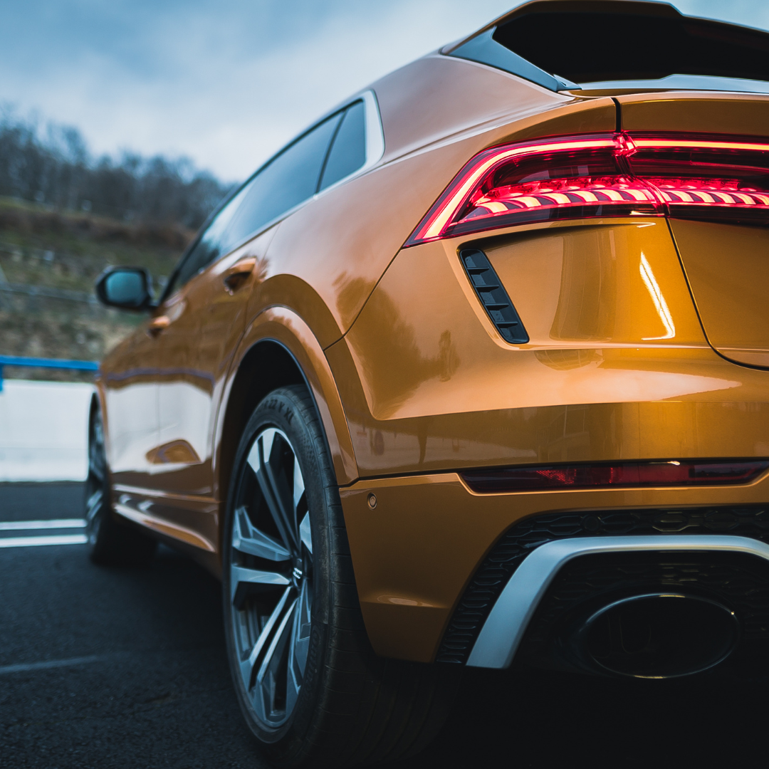 A sleek and polished orange SUV in perfect condition parked outdoors.