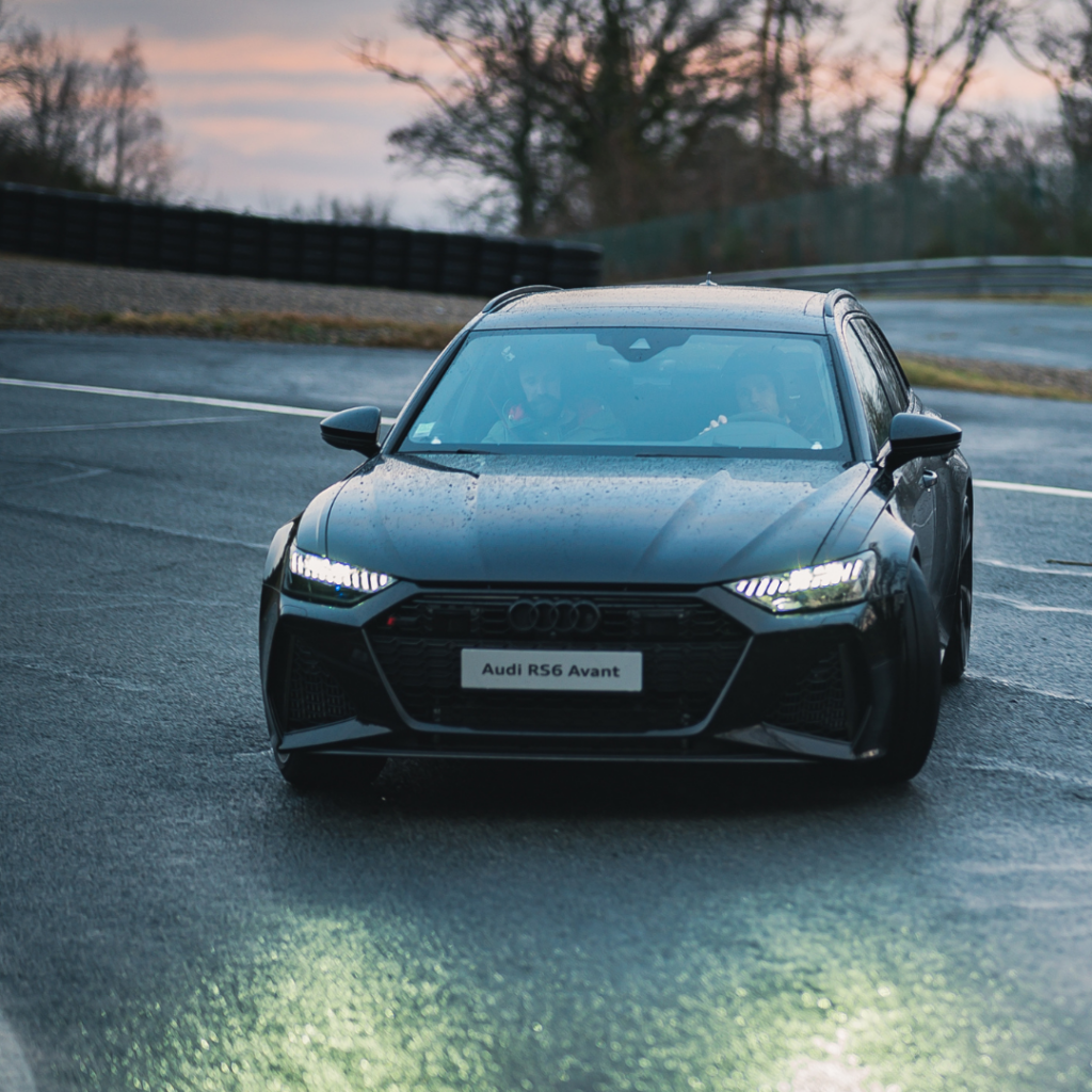 Black Audi RS6 Avant on a wet racetrack for checking car noises